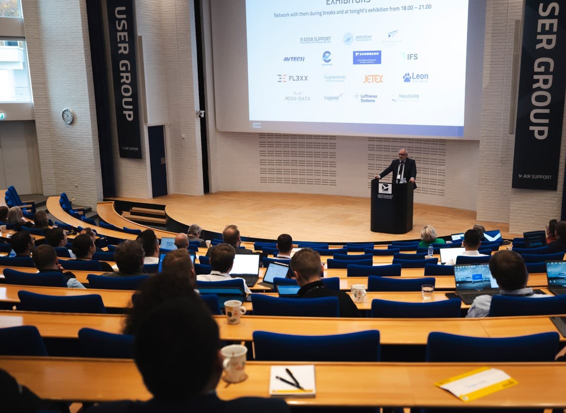 Photo of the UGM host welcoming guests and exhibitors in the auditorium at the User Group Meeting.