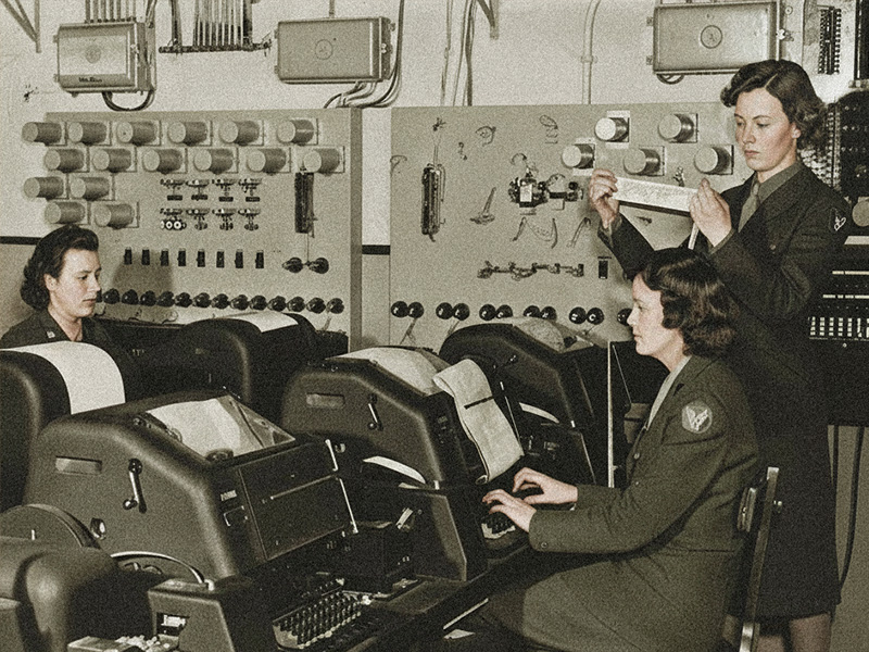 Web_Banner_09_MFOF_800x600_ Banner image showing women in uniform operating vintage teletype machines in an early aviation communication centre, illustrating NOTAM evolution.